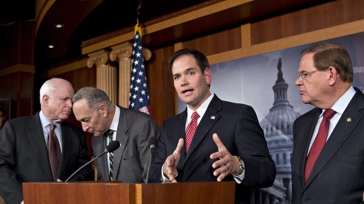Los senadores republicano Marco Rubio (Florida, centro) y demócrata Bob Menéndez (Nueva Jersey, der.) participan en una conferencia de prensa en el Congreso en Washington el 28 de junio de 2013. A la izquierda estan los senadores John McCain (R) y Chuck Schumer (D).