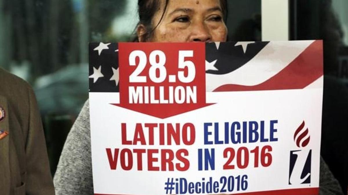 Georgina Arciniegas muestra un cartel en apoyo al voto latino en Doral en junio.
