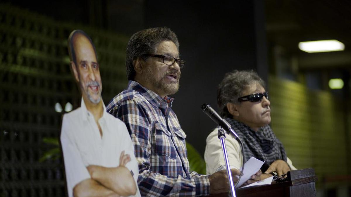 Los negociadores de las FARC, Iván Márquez (centro) y Jesús Santrich, dan una conferencia de prensa el 23 de septiembre de 2014 en La Habana, acompañados de una foto del guerrillero alias Simón Trinidad. Márquez y Santrich anunciaron el jueves la formación de un nuevo grupo guerrillero.