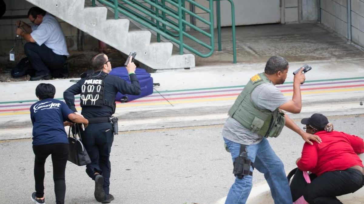 Agentes de policía evacúan a civiles cerca de un estacionamiento en el Aeropuerto Internacional de Fort Lauderdale/Hollywood, el viernes 6 de enero, cuando un ex soldado abrió fuego contra un grupo de pasajeros.