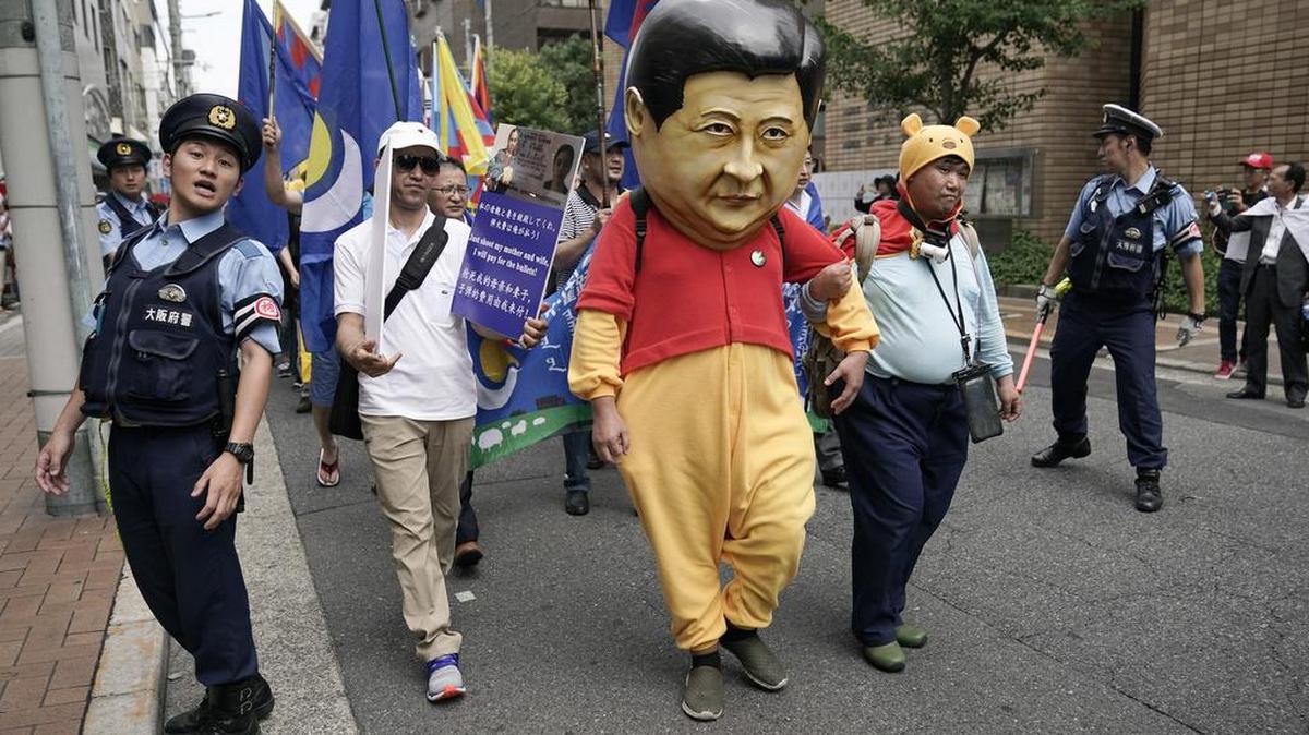 Un manifestante vestido del presidente Xi Jinping marcha junto a decenas de personas en una protesta contra el gobierno chino durante la cumbre del G-20, el sábado 29 de junio de 2019, en Osaka, Japón.