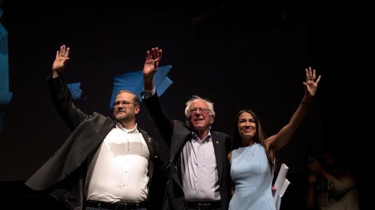 Alexandria Ocasio-Cortez, el senador Bernie Sanders y James Thompson, un candidato al Congreso de Kansas, en un mitin de campaña en Wichita, el 20 de julio de 2018.