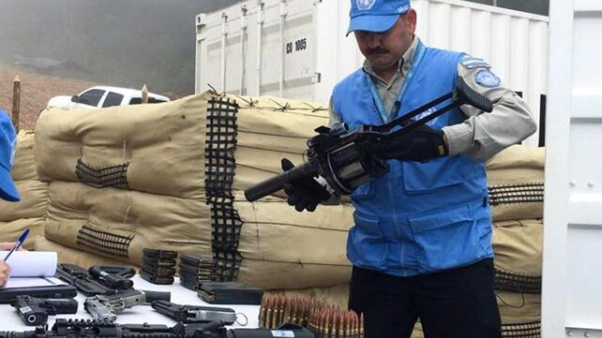 Un miembro de las Naciones Unidas que monitorea el proceso de paz en Colombia revisa una de las armas entregadas por los rebeldes de las FARC, en el sur del país, el 13 de junio.