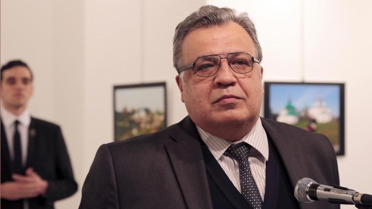 El embajador de Rusia en Turquía, Andrei Karlov, habla en una exposición de fotos en Ankara minutos antes de ser asesinado por la persona que aparece detrás, el lunes 19.