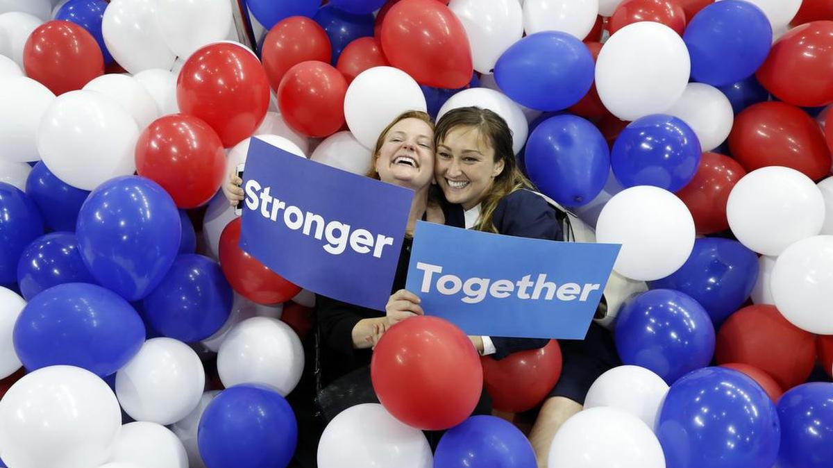 Dos trabajadoras de la campaña de Hillary Clinton posan con algunos de los globos arrojados al final de la Convención Nacional Demócrata en Filadelfia.