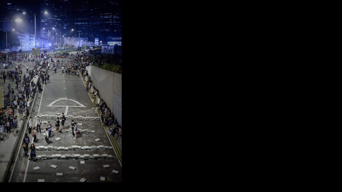 
Manifestantes a favor de la democracia cierran una vía con bloques de concreto cerca de las oficinas del gobierno en Hong Kong, el miércoles pasado.
