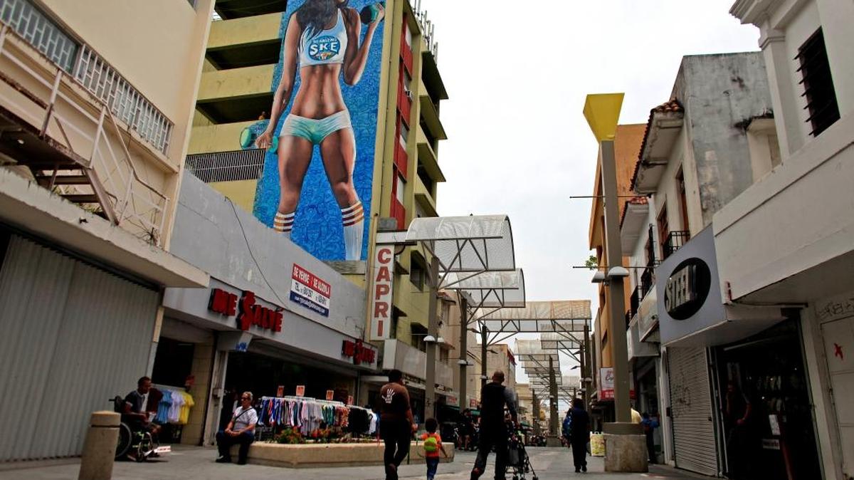 Varias personas recorren una zona comercial en San Juan, en julio del 2015, donde muchos negocios han cerrado. La crisis económica que azota a Puerto Rico ha generado un éxodo hacia Estados Unidos.