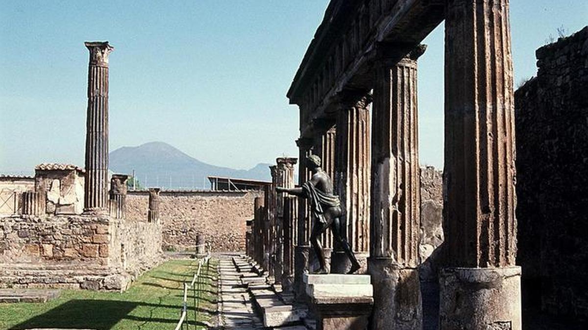 Una sección de la ruinas de Pompeya con el monte Vesubio en el fondo, en Italia.