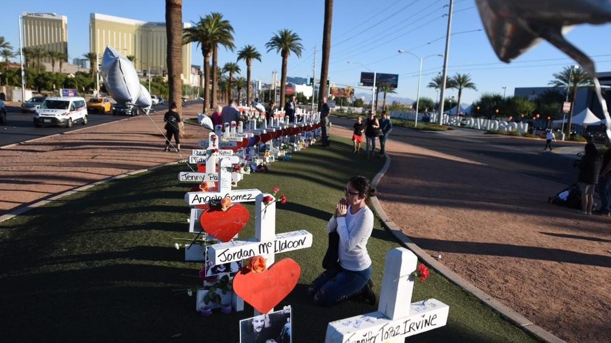 Una mujer reza junto a 58 cruces colocadas cerca del hotel Mandalay Bay, en Las Vegas, en memoria de las víctimas de la matanza cometida en esa ciudad el 1 de octubre.