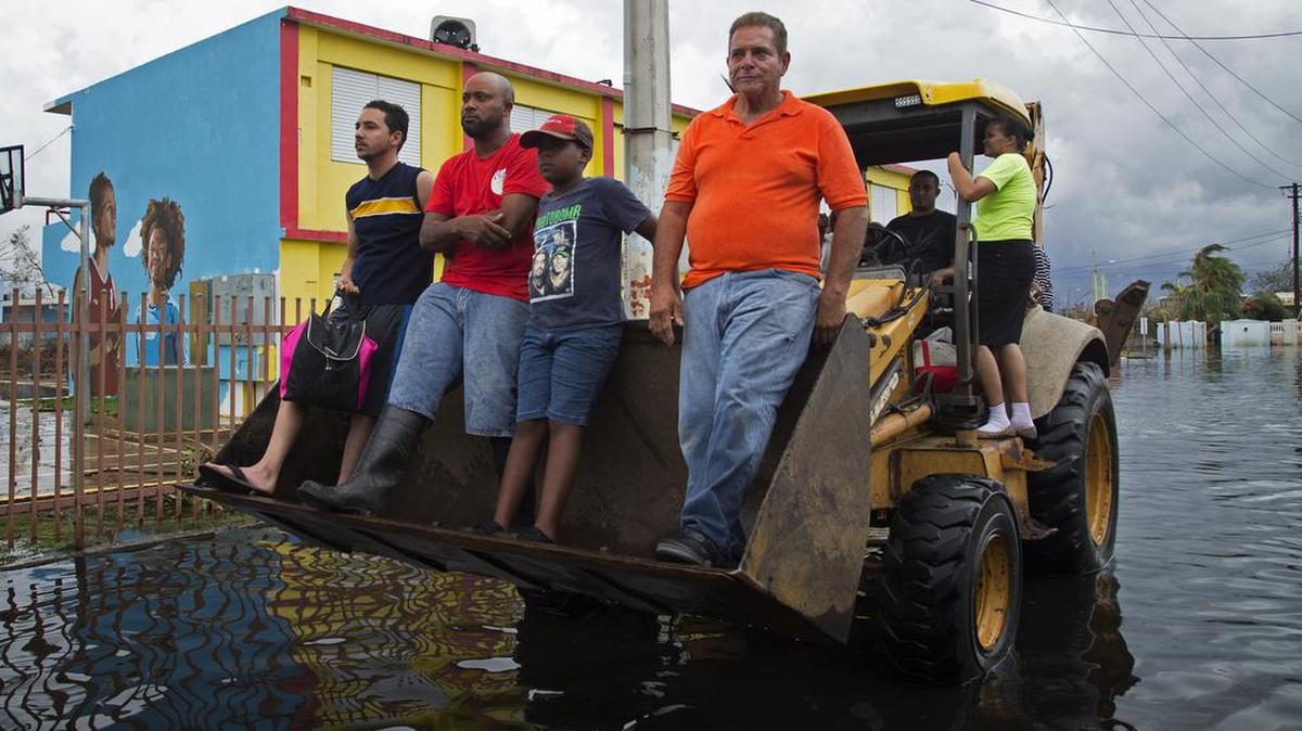 Miembros de la comunidad de Miñi Miñi son rescatados por vecinos usando maquinaria pesada, en Loíza, Puerto Rico, el 21 de septiembre de 2017. Loíza fue una comunidad costera severamente dañada por los vientos severos del huracán María.