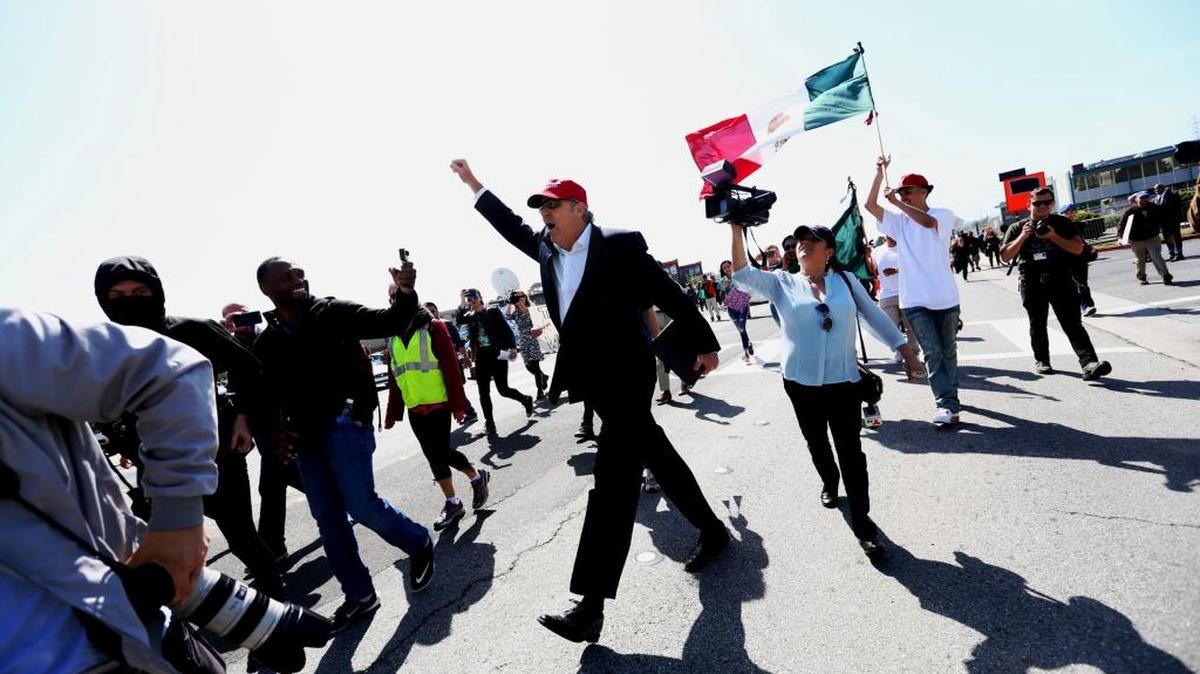 Un partidario de Donald Trump, imitando al magnate, interviene en una protesta contra el candidato republicano en Burlingame, California, el 29 de abril.