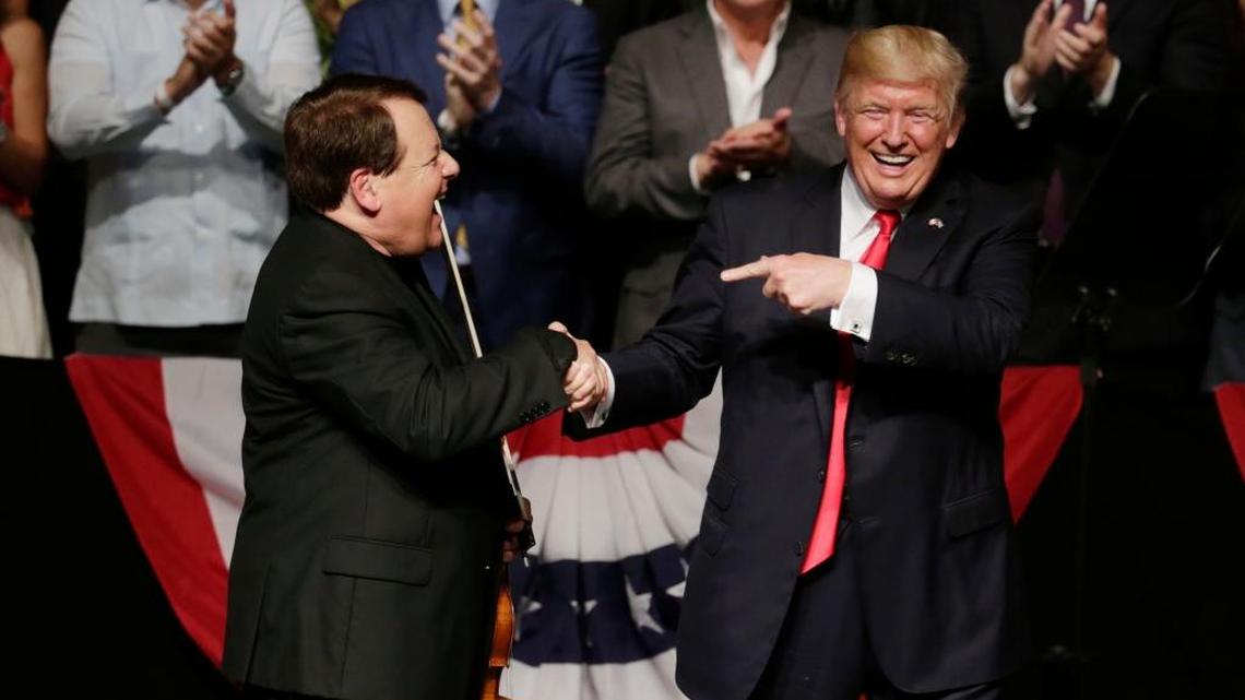 President Donald Trump salutes violinist  Luis Haza for his presentation during an event at Manuel Artime Theater in Miami. Trump announced a tougher Cuba policy at the theater on June 16, 2017.
