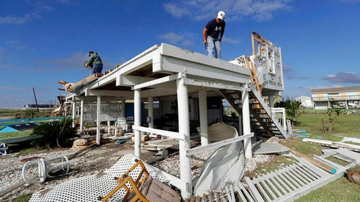 Joe Tijerina (Der.) intenta salvar algunas pertenencias de su casa, destruida por el huracán Harvey, el 29 de agosto, en Rockport, Texas.