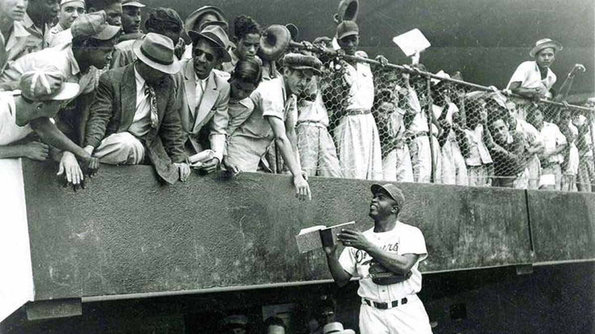 JACKIE ROBINSON saluda y firma autógrafos a aficionados cubanos durante la visita de los Dodgers de Brooklyn a La Habana en marzo de 1947.