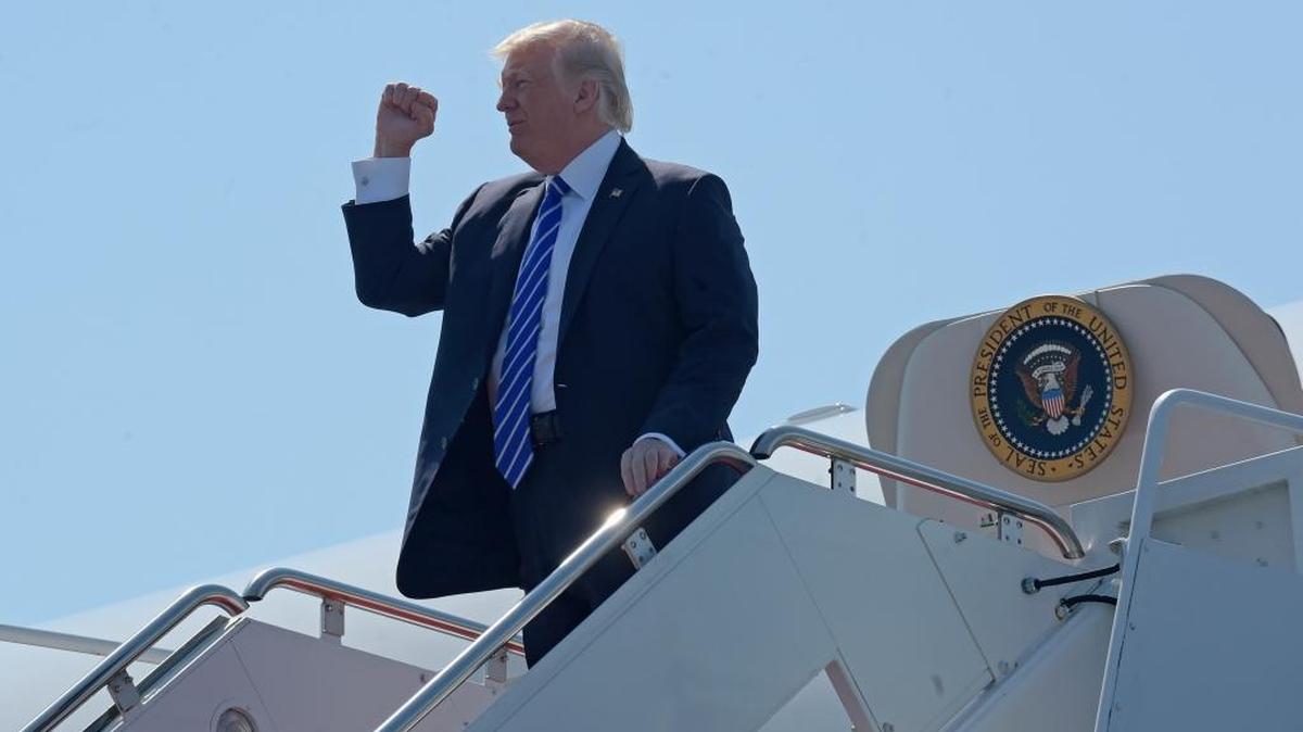 El presidente Donald Trump saluda al salir del Air Force One en Groton-New London Airport en Connecticut, el 17 de mayo