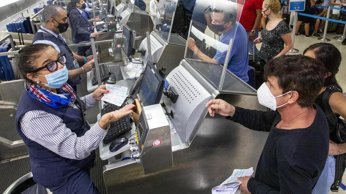 Empleados de American Airlines ayudan a los viajeros a inscribirse antes de su vuelo internacional desde el Aeropuerto Internacional de Miami el lunes 7 de junio de 2021.