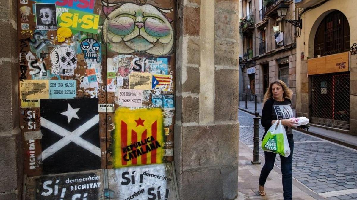 Una mujer camina junto a un graffiti proindependentista en una calle de Barcelona, el 22 de octubre.