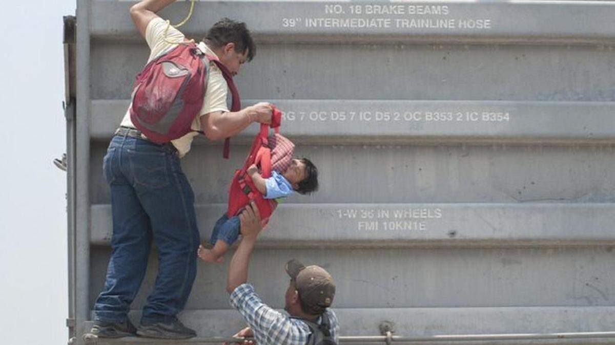 Los inmigrantes arriesgan sus vidas y las de su familia al abordar el tren en marcha.