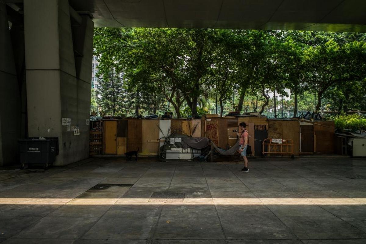 Un turista toma fotos de refugios improvisados por los desamparados como parte de un tour guiado de Hong Kong Free Tours, que se aparta del distrito de compras para mostrar otros lugares de la ciudad.