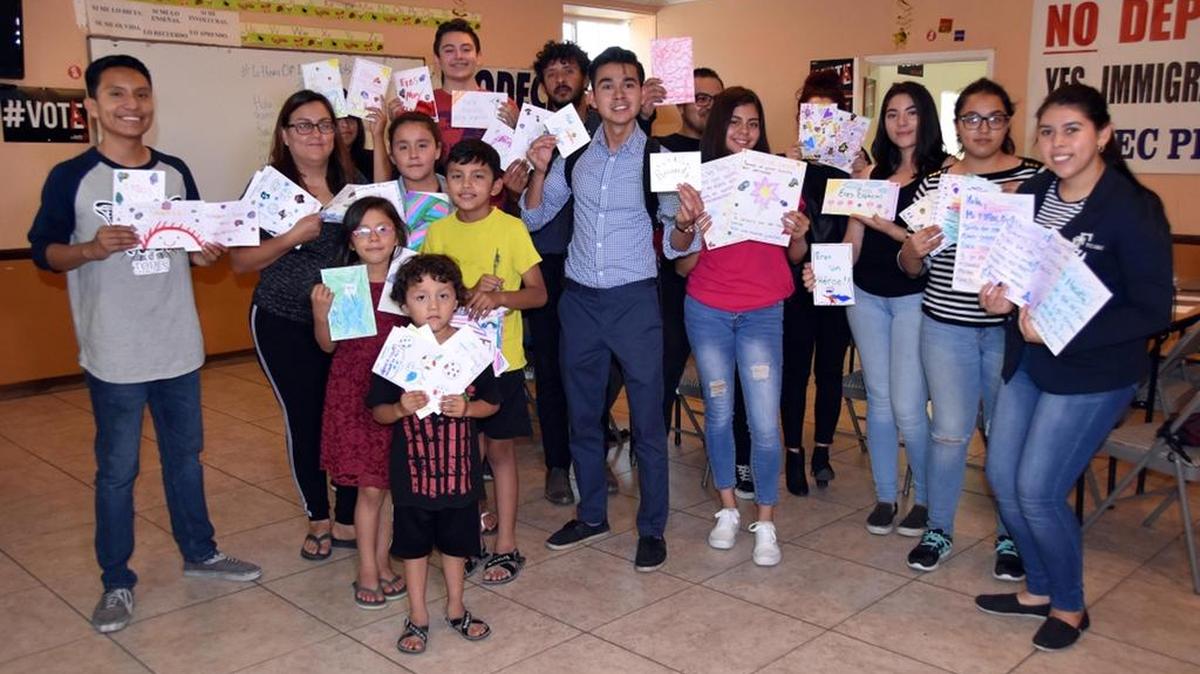 Jóvenes que en su momento llegaron como indocumentados a Estados Unidos posan con las cartas que escribieron a los nuevos niños albergados en los centros de detención del Servicio de Inmigración y Aduanas (ICE).