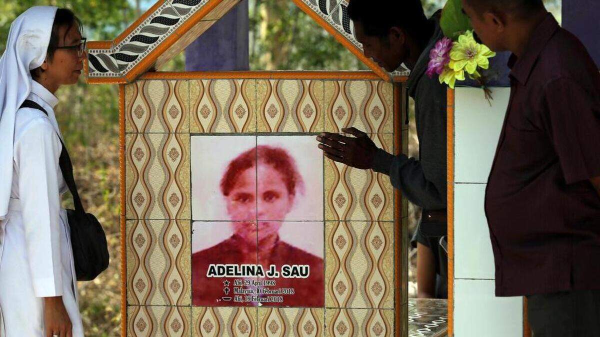 La monja Laurentina (izq) al lado de la tumba de Adelina Sau en Abi village en West Timor, Indonesia. Adelina murió cuando trabajaba como empelada doméstica para una familia en Malasia.