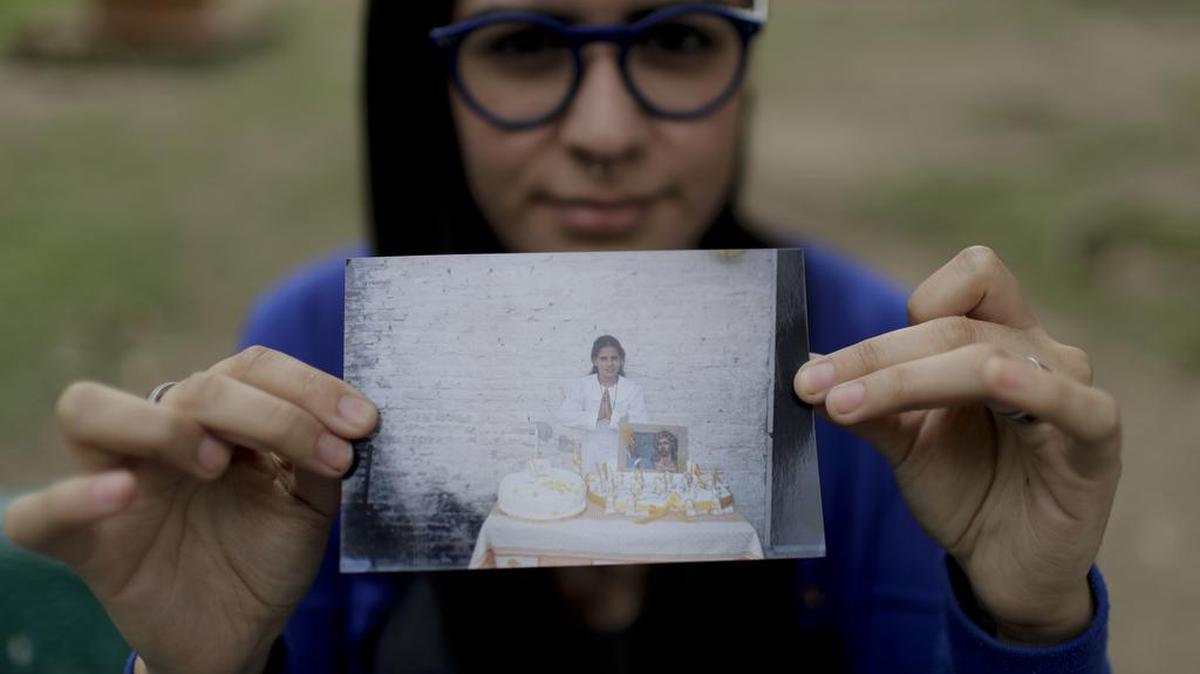 Karen Maydana, de 22 años, muestra una foto de cuando hizo la Primera Comunión en Caseros, en la provincia de Buenos Aires
