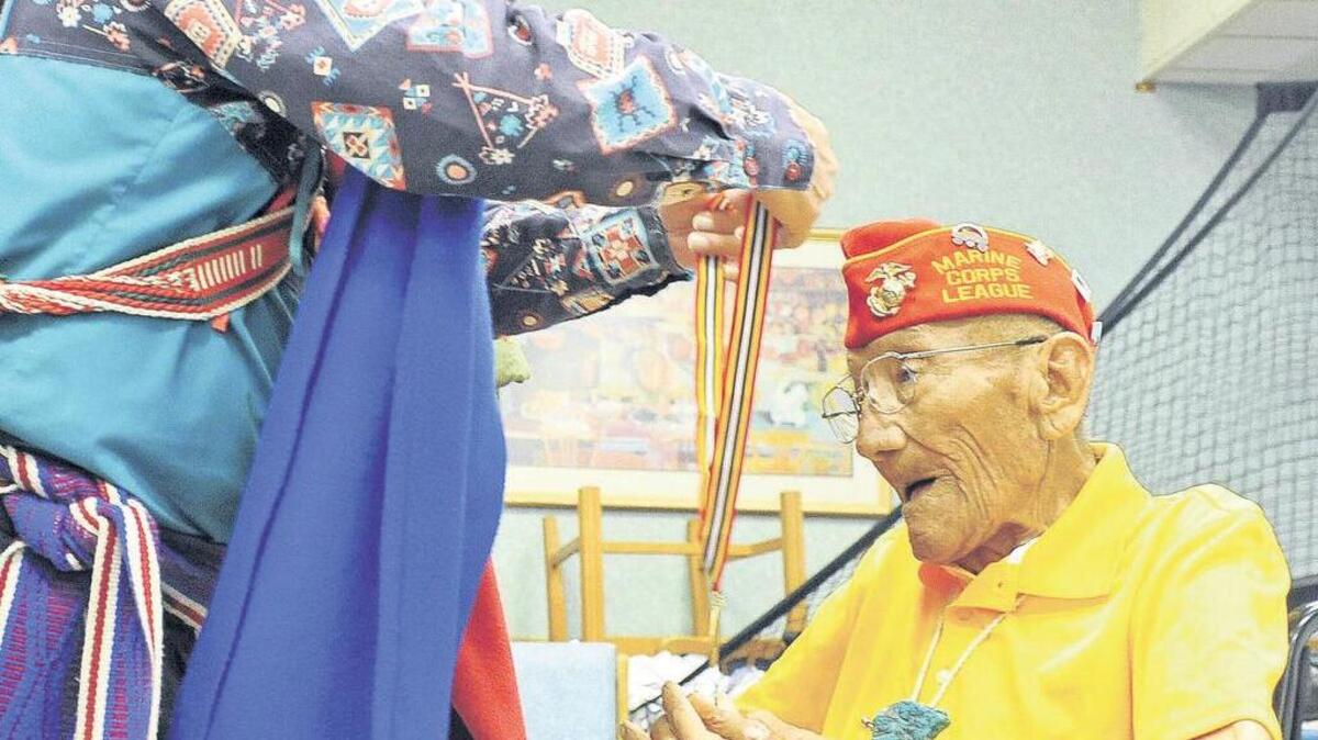 Larry Kimmel con la Orden Militar de Purple Heart le entrega la Medalla de Valor a Sgt. Allen D. June uno de los indios navajos ‘code talkers’.