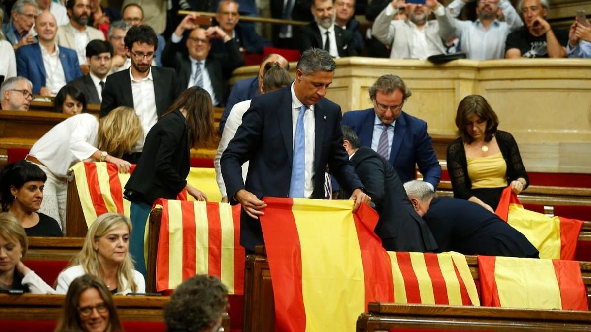 Miembros del Partido Popular en Cataluña despliegan la bandera española en el Parlamento catalán antes de abandonar la sesión por desacuerdos sobre el referendo a favor de la independencia que se celebra el 1ro de octubre.