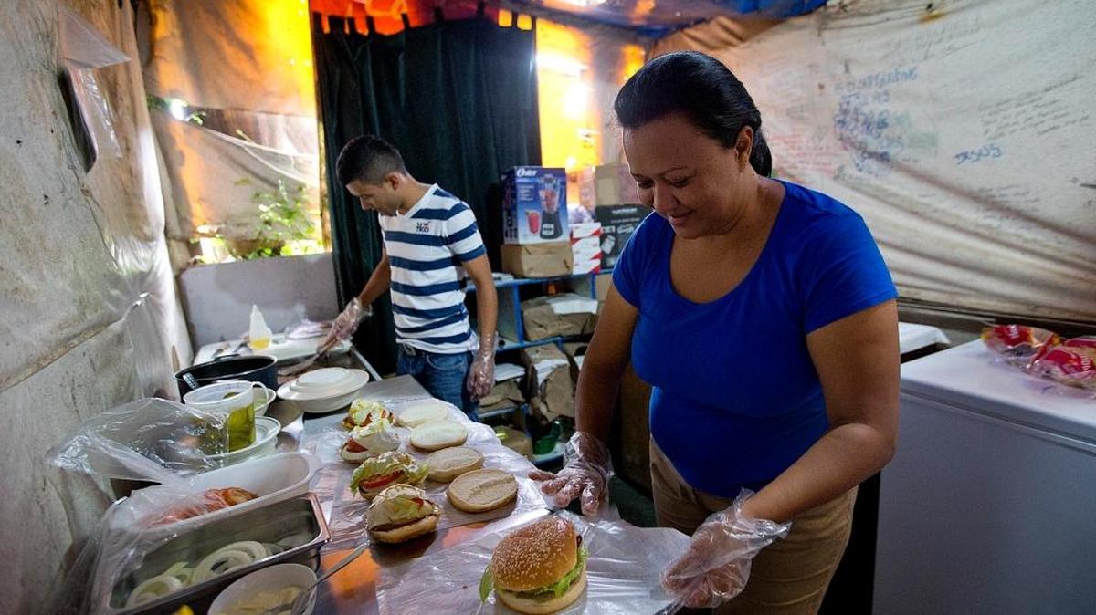 El ex pandillero Jess “Chuy” Lanza trabaja con su mamá en un negocio de hamburguesas en Tegucigalpa, Honduras. El es uno de los beneficados de un programa de ayuda para estudios de la USAID.