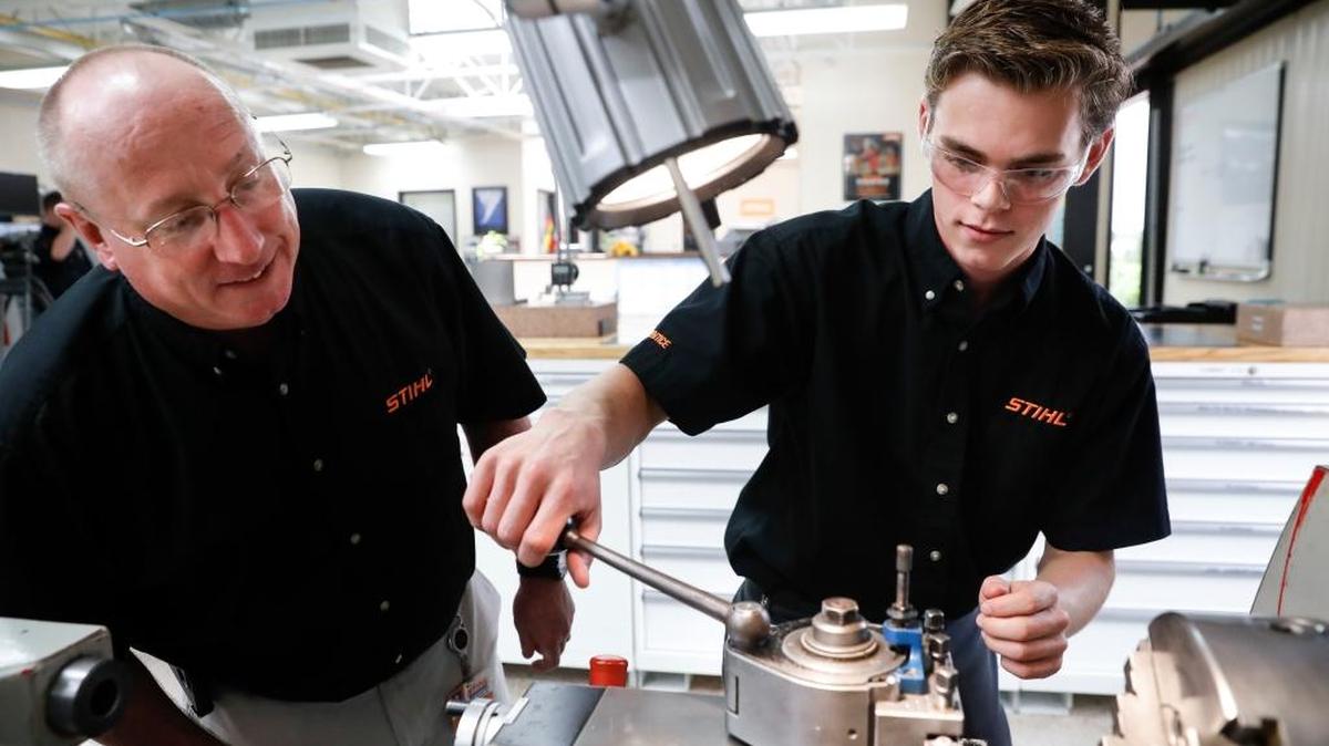 El aprendiz Ryan Buzzy, de 18 años, trabaja con Skip Johnson, en un programa de entrenamiento en Stihl Inc. en el que combinará conocimientos de ingeniería con los de computadoras.
