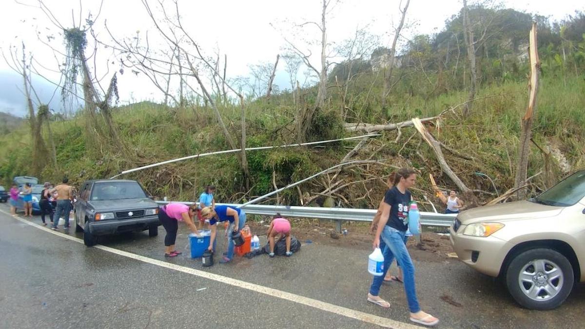 Residentes de Utuado recogen agua de manantial a la orilla de la carretera #10.