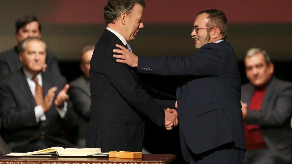 El presidente de Colombia, Juan Manuel Santos (izq.) con Rodrigo Londoño, “Timochenko”, líder de las FARC, luego de la firma de un nuevo acuerdo de paz, en el Teatro Colón, Bogotá, el 24 de noviembre.