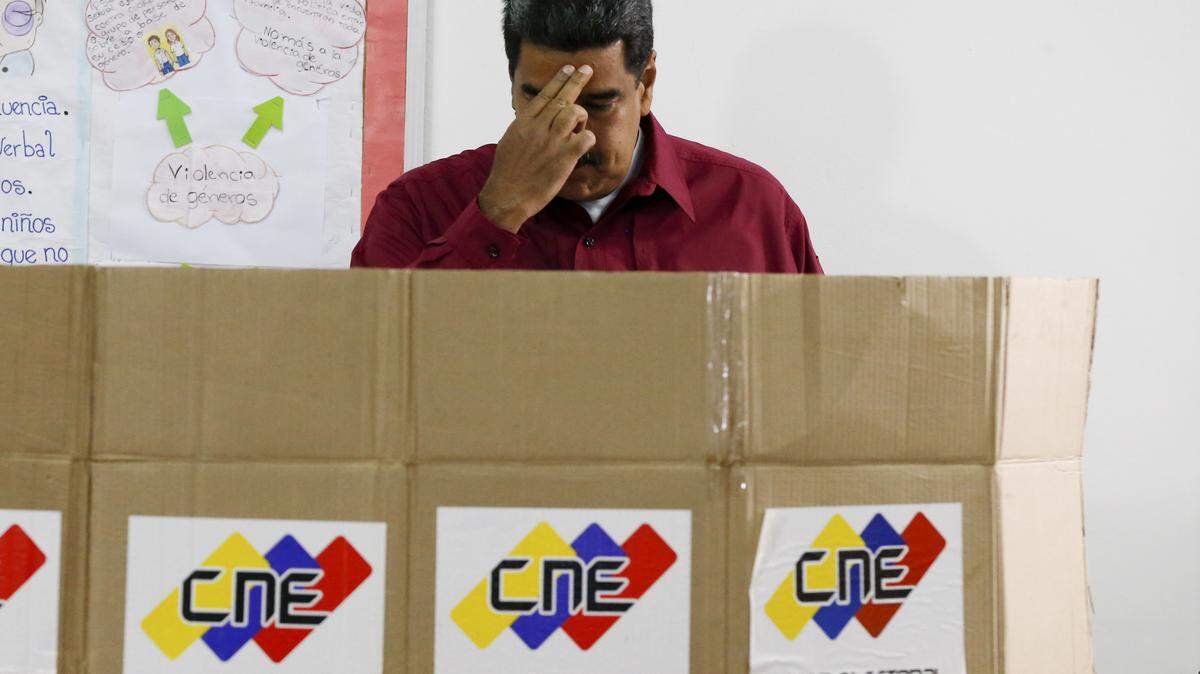 El gobernante Nicolás Maduro hace la señal de la cruz antes de votar en domingo en Caracas.