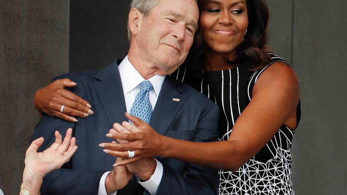 La primera dama Michelle Obama abraza al ex presidente George W. Bush durante la ceremonia de inauguración del Smithsonian Museum of African American History and Culture en el National Mall en Washington, el 24 de septiembre.