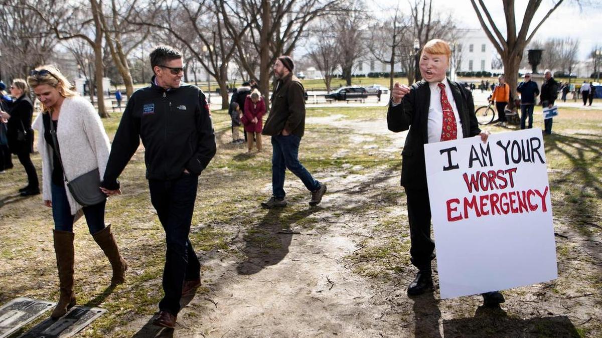 Un manifestante disfrazado del presidente Donald Trump sostiene una pancarta que dice “Soy tu peor emergencia”, el lunes durante una protesta frente a la Casa Blanca.