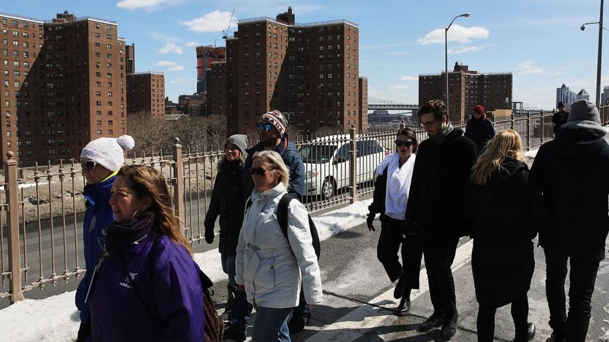 Varias personas pasan cerca de viviendas públicas en el sur de Manhattan, en Nueva York. El presupuesto del presidente Donald Trump reduciría miles de millones de dólares al Departamento de Vivienda y Desarrollo Urbano.