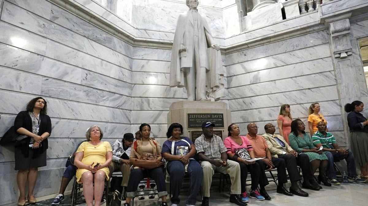 Un grupo de manifestantes en el Capitolio de Kentucky, en Frankfort, exige al gobernador del estado, Matt Bevin, que quite una estatua del presidente confederado Jefferson Davis (al fondo), el 30 de agosto.