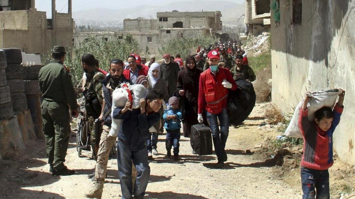 Un grupo de civiles deja sus viviendas en la región de Guta, cerca de Damasco, la capital siria, el 25 de marzo, después de semanas de feroces bombardeos.