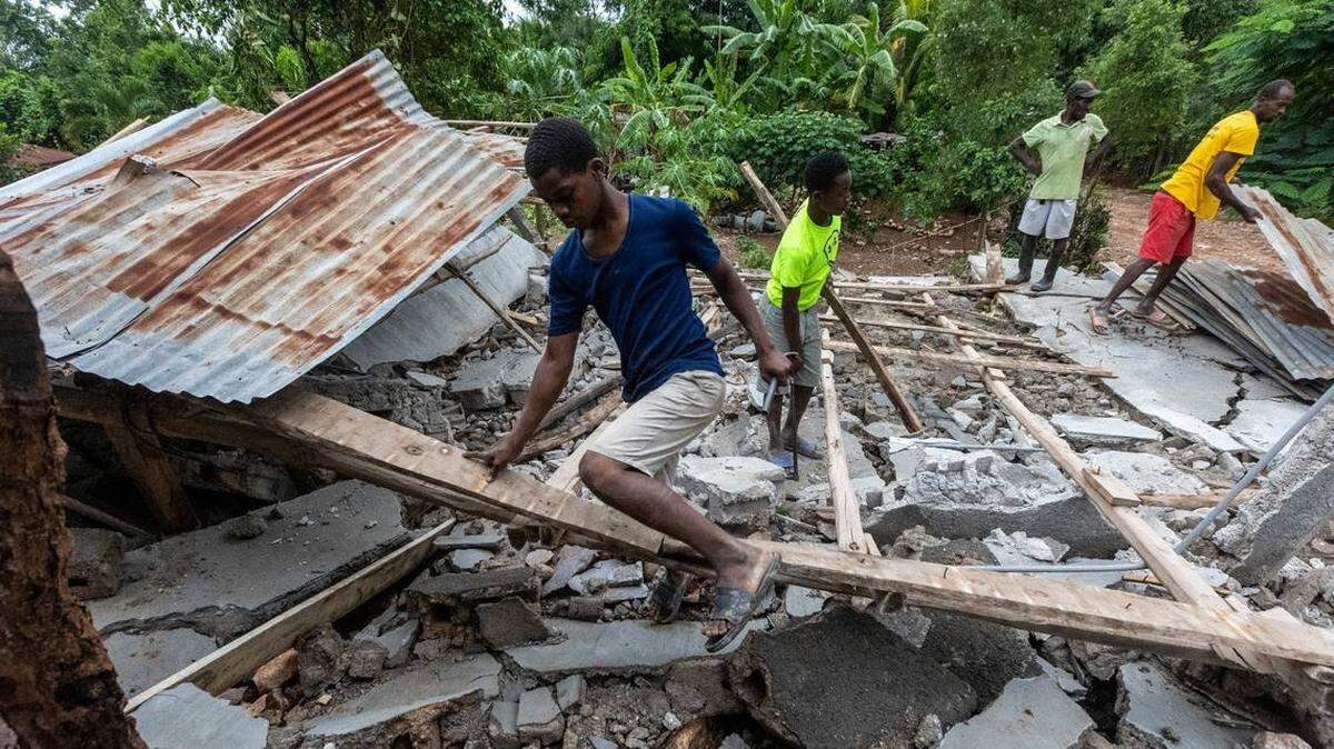 Varias personas tratan de recuperar madera y otros materiales de una casa destruida en la población de Fleurant, Haití, en donde muchos edificios de este pequeño pueblo fueron derribados por el terremoto del 14 de agosto.