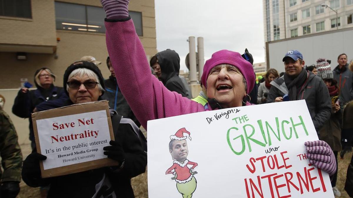 Un grupo de manifestantes protesta en Washington el 14 de diciembre contra la decisión de eliminar protecciones para evitar la desigualdad en la Internet. Diane Tepfer lleva un cartel con una caricatura del presidente de la Comisión Federal de Comunicaciones, Ajit Pai, como el Grinch.