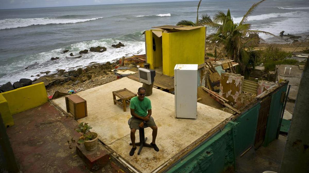 Un hombre se sienta en los restos de su casa en la costa de San Juan, tras el paso del huracán María por Puerto Rico el 20 de septiembre. La cifra de muertos podría estar cerca de los 500.