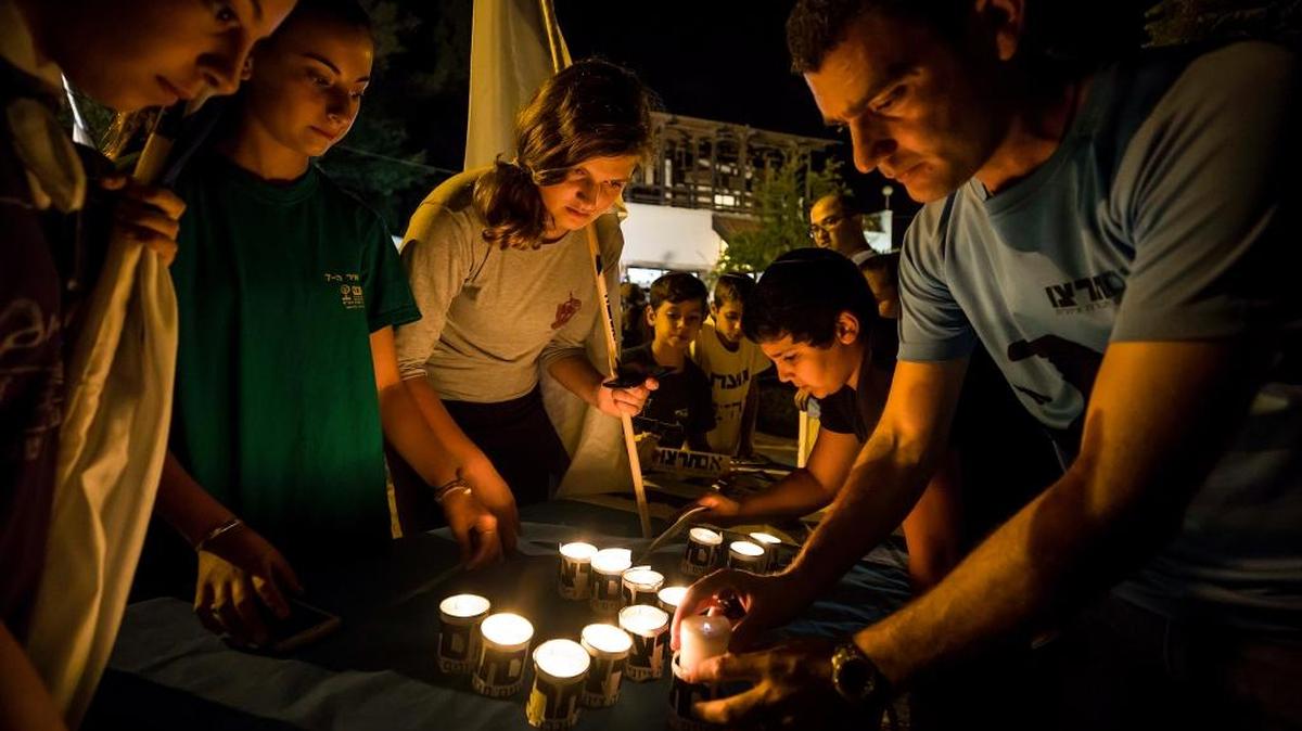 Israelíes encienden velas en el asentamiento de Halamish, el 22 de julio. El ejército israelí envió más tropas a la Franja Oeste después de un nuevo ataque de un palestino a una familia israelí y al aumento de tensiones.