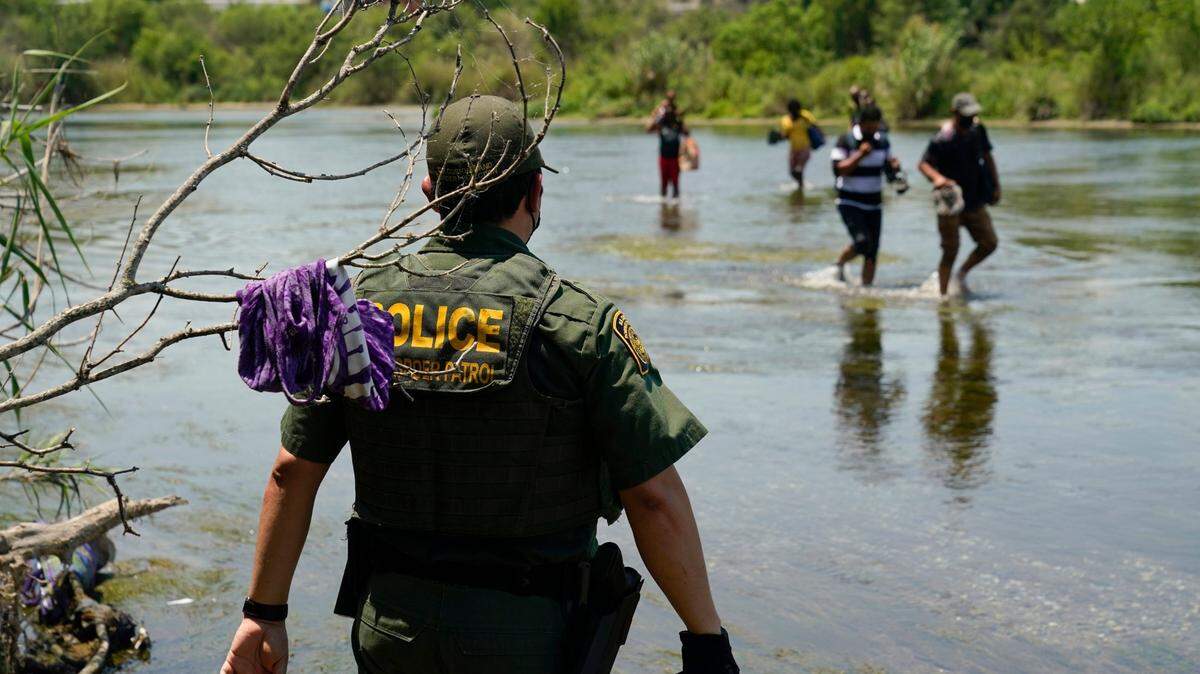 Un agente de la Patrulla Fronteriza de EEUU mira como un grupo de inmigrantes cruza el Río Grande, en camino a entregarse a las autoridades una vez que crucen la frontera México-Estados Unidos, cerca de Del Río, Texas, el 15 de junio de 2021. (AP foto/Eric Gay, archivo)