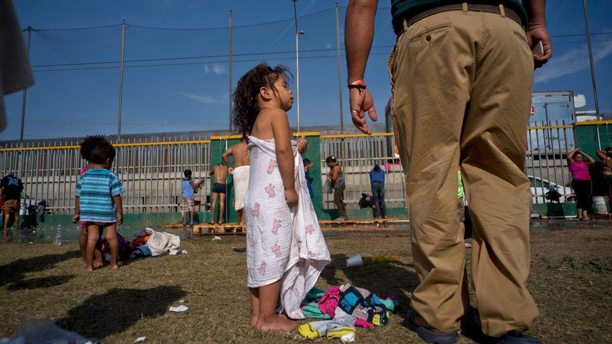 Una niña, parte de la caravana de inmigrantes, habla con su padre después de tomar una ducha en un refugio de Tijuana, México, el 21 de noviembre de 2018.