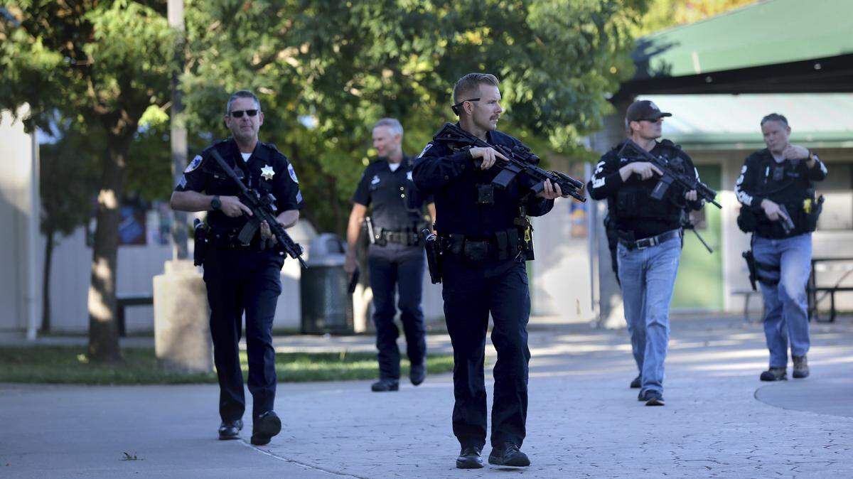 Santa Rosa police officers carry guns as they search the campus of Ridgway High School for suspects after a shooting at the school in Santa Rosa, Calif., Tuesday, Oct. 22, 2019. (Beth Schlanker/The Press Democrat via AP)