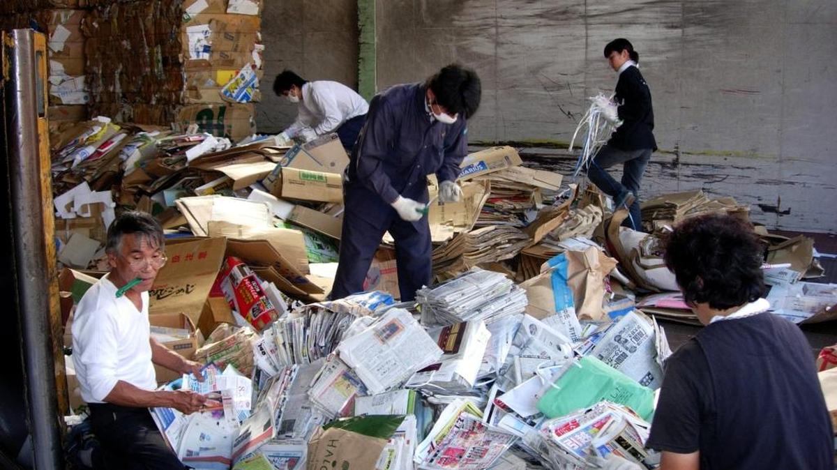 Trabajadores en Tokio clasifican papel usado para reciclarlo y exportarlo a China.