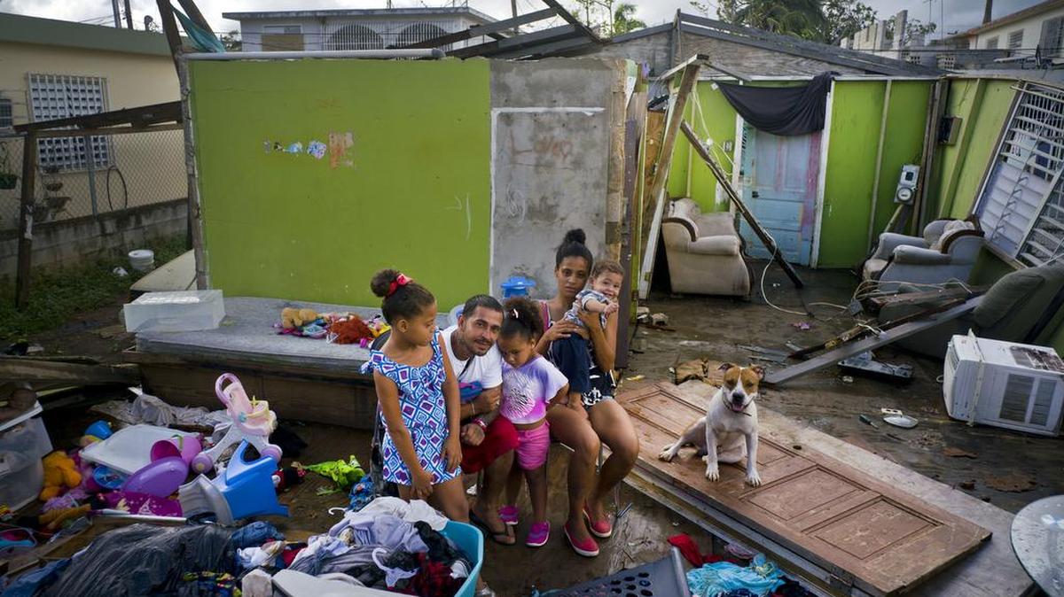 Una familia se reúne en los restos de su casa, destruida por el huracán María en Toa Baja, Puerto Rico, en octubre.