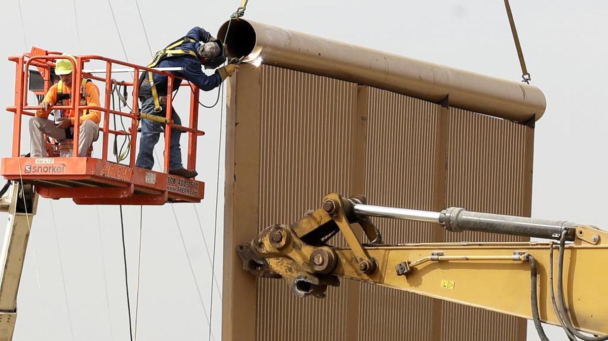 Varios obreros construyen un prototipo de muralla cerca de la frontera con la ciudad mexicana de Tijuana, en octubre del 2017. El presidente Trump insiste en levantar un muro en el límite con México.