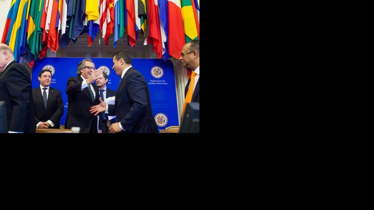 
El ministro de Relaciones Exteriores de Guatemala, Carlos Raúl Morales (centro, der.) felicita al canciller uruguayo, Luis Almagro, por su elección como secretario general de la OEA, el 18 de marzo en Washington.
