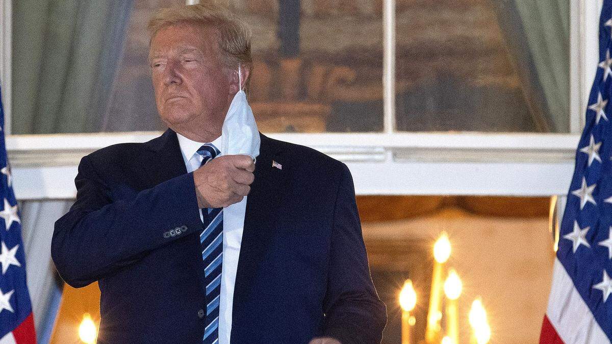Donald Trump, presidente de EEUU, se quita la máscara a su llegada a la Casa Blanca tras ser dado de alta del centro médico militar Walter Reed, el 5 de octubre de 2020 en Washington DC. (Win McNamee/Getty Images/TNS)